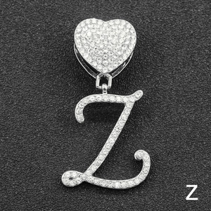 Macro detail of iced-out silver cursive letter Z pendant with heart buckle and clear zircons