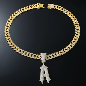 Détail macro du collier cubain doré avec pendentif lettre A gothique serti de diamants