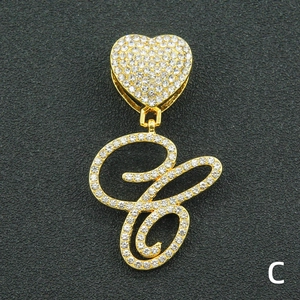 Close-up of iced out heart pendant with cursive letter C in gold and white crystals