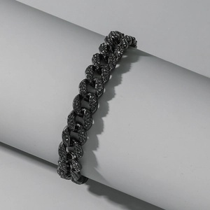 Macro detail of iced-out black Cuban link anklet with shimmering pavé set crystals