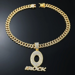 Close-up of iced-out gold Cuban chain with O-Block pendant featuring crystal rhinestones