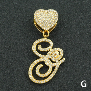 Close-up of golden heart buckle and cursive alphabet pendant set with sparkling crystals