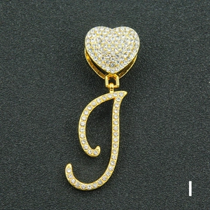 Macro shot of hip hop letter I pendant with iced out rhinestones and heart buckle