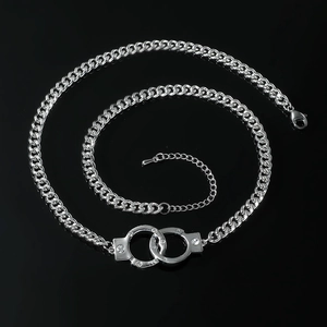 Collana a catena cubana argento con ciondolo a manette e zirconi su sfondo nero lucido
