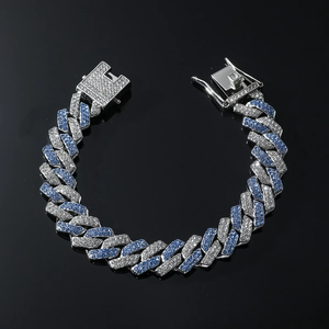 Détail d'un bracelet cubain hip-hop avec strass bleus et blancs sur un fond en verre noir