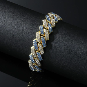 Gros plan d'un bracelet gourmette plaqué or avec des strass bleus et blancs