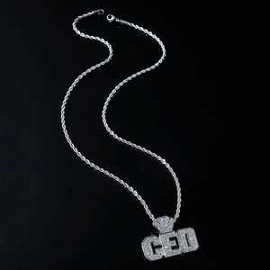 Détail du pendentif CEO glacé avec couronne et chaîne de torsion en argent sur fond noir