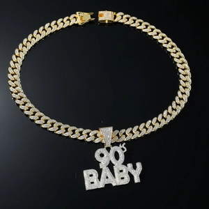 Detailed close-up of iced out 90's BABY pendant with gold Cuban chain link