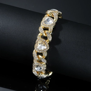 Detailed macro view of gold-tone Cuban chain bracelet with sparkling heart-shaped crystals