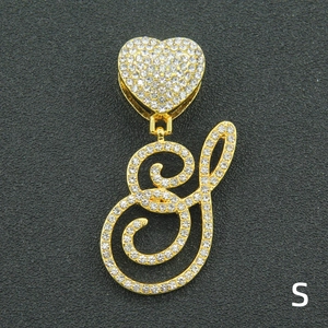 Detail of gold iced out S letter pendant with heart clasp and sparkling crystal rhinestones