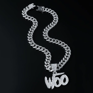 Detail of silver Cuban link necklace with iced-out WOO letter pendant and rhinestones