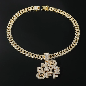 Close-up of gold iced-out NO DAYS OFF letter pendant on heavy Cuban link chain