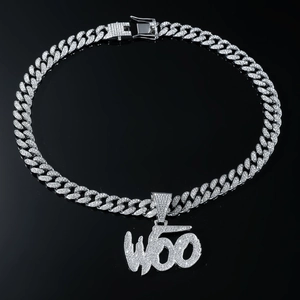 Macro view of silver cuban link chain with iced out W60 pendant on black mirror