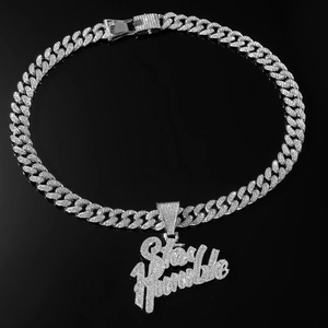 Nahaufnahme des Stay Humble Schriftzugs und der silbernen Cubankette mit Strasssteinen