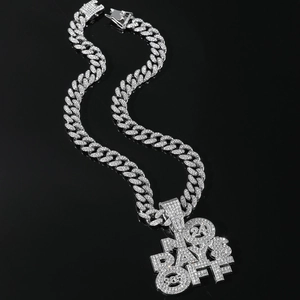 Macro detail of iced-out Cuban link necklace with NO DAYS OFF diamond-encrusted pendant