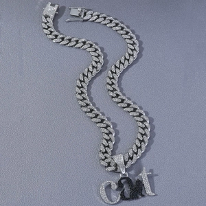 Gros plan sur la chaîne cubaine argentée avec pendentif chat pavé de strass pour homme