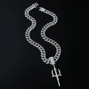Detailed macro of a silver cuban link chain with a trident pendant and sparkling crystals