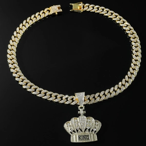 Detailed view of gold plated Cuban chain and iced out King crown pendant with rhinestones