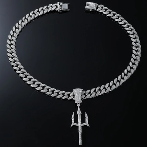 Macro shot of silver hip hop cuban chain with rhinestone encrusted trident pendant
