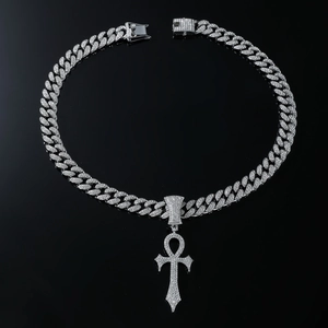 Gros plan d'une chaîne cubaine argentée avec pendentif croix Ankh serti de diamants