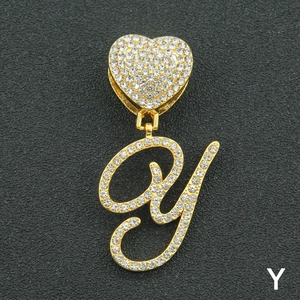 Macro shot of gold-plated iced out letter Y pendant with heart buckle and clear crystals