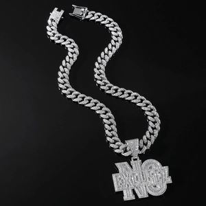 Macro detail of iced out silver NO EXCUSE letter pendant and sparkling Cuban link chain