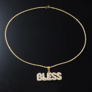 Détail macro du pendentif lettre BLESS plaqué or avec sertissage de zircons brillants