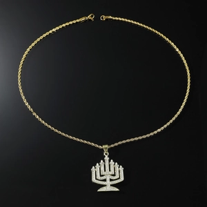 Detailed macro view of iced out Menorah pendant with gold rope chain and crystals
