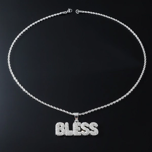 Détail du pendentif lettres BLESS argentées serties de strass sur une chaîne torsadée