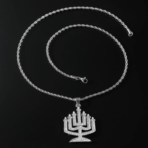 Macro shot of silver hip-hop Menorah pendant with iced-out crystals on rope chain