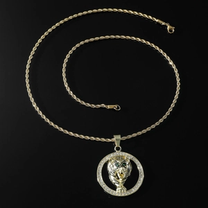 Vue détaillée du pendentif tête de tigre aux yeux verts et bordure en cristaux
