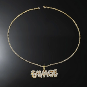 Détail du pendentif SAVAGE doré serti de cristaux brillants sur une chaîne de type corde