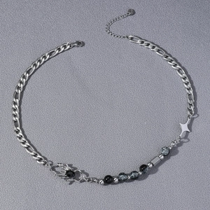 Punk spider necklace with silver cross and cracked marble beads on gray background