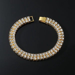Luxury gold double-row tennis bracelet with clear crystals on a reflective black surface