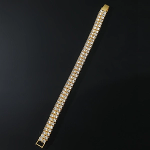 Macro detail of men's double-row rhinestone bracelet with golden finish and crystal inlay