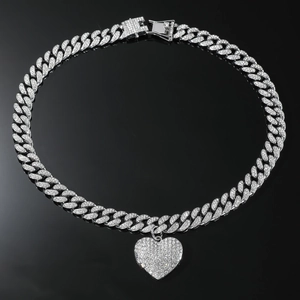 Macro-opname van de iced out zilveren hart hanger en diamant cubaanse schakelketting