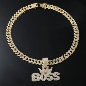 Macro shot of gold-plated Cuban chain with sparkling diamond-set BOSS crown pendant