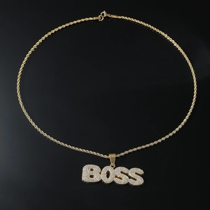 Detailed macro view of gold hip hop BOSS letter pendant with micro-pave crystals and rope chain