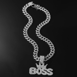 Macro shot of silver Cuban chain with diamond-encrusted BOSS crown pendant for men