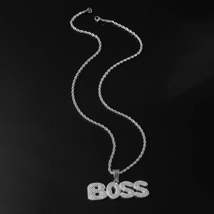 Macro view of iced out BOSS pendant necklace featuring rhinestones on a rope chain