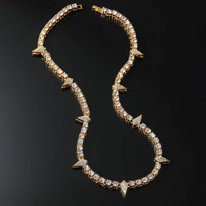 Hip hop gold tennis necklace featuring sparkling zircon arrows on a black background