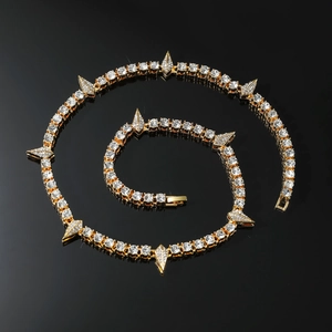 Macro detail of gold Cuban link chain with water drop diamonds and sharp claw pendants