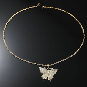 Détail du pendentif papillon doré avec oxydes de zirconium sur une chaîne corde