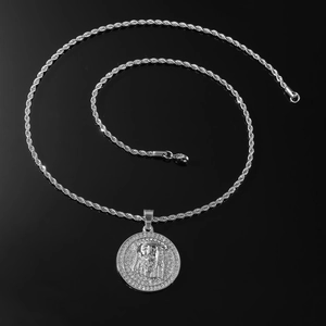 Silver Jesus medallion pendant with iced-out border and rope chain on reflective black base