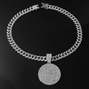 Detailed macro of iced-out Stay Humble Hustle Hard pendant on a silver Cuban chain link