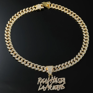 Dettaglio macro della collana cubana dorata con ciondolo REAL HASTA LA MUERTE e diamanti