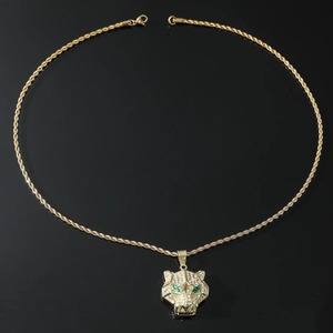 Detailed macro of gold hip hop leopard head pendant with green eyes and rope chain