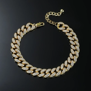 Bracelet de cheville gourmette dorée hip hop avec strass sur fond noir brillant