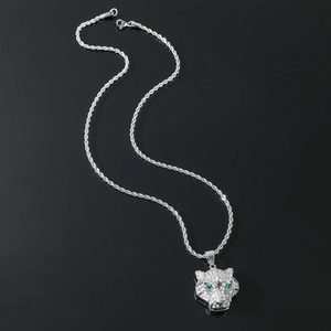 Macro detail of a silver leopard head pendant with green eyes and white zircon stones