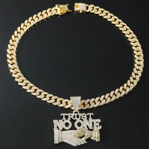 Macro view of iced out golden Cuban link chain with Trust No One pendant detail
